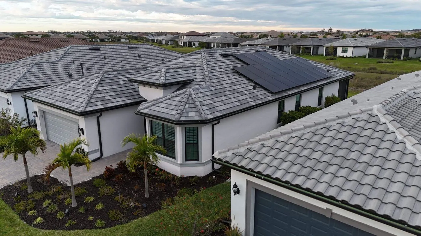 Aerial view of solar panels on a gray tile roof in a Florida neighborhood installed by Coastal Energy