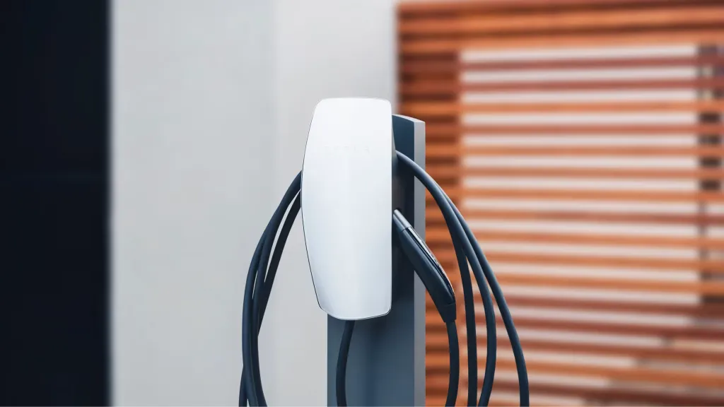 Tesla Wall Connector mounted on a garage wall next to an electrical panel