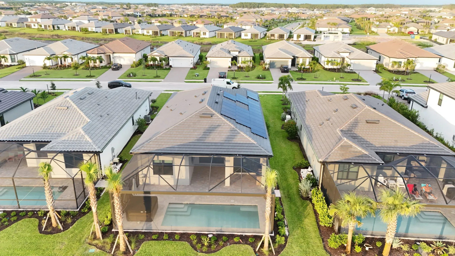 Aerial view of a Florida neighborhood with a solar panel array on a tile roof pool home installed by Coastal Energy