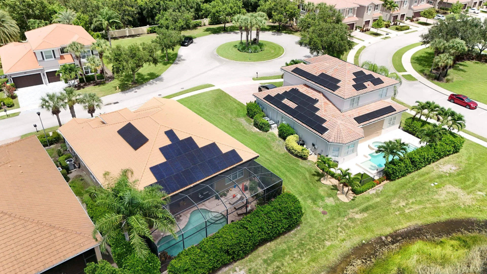 Aerial view of two Florida homes with solar arrays on barrel tile roofs