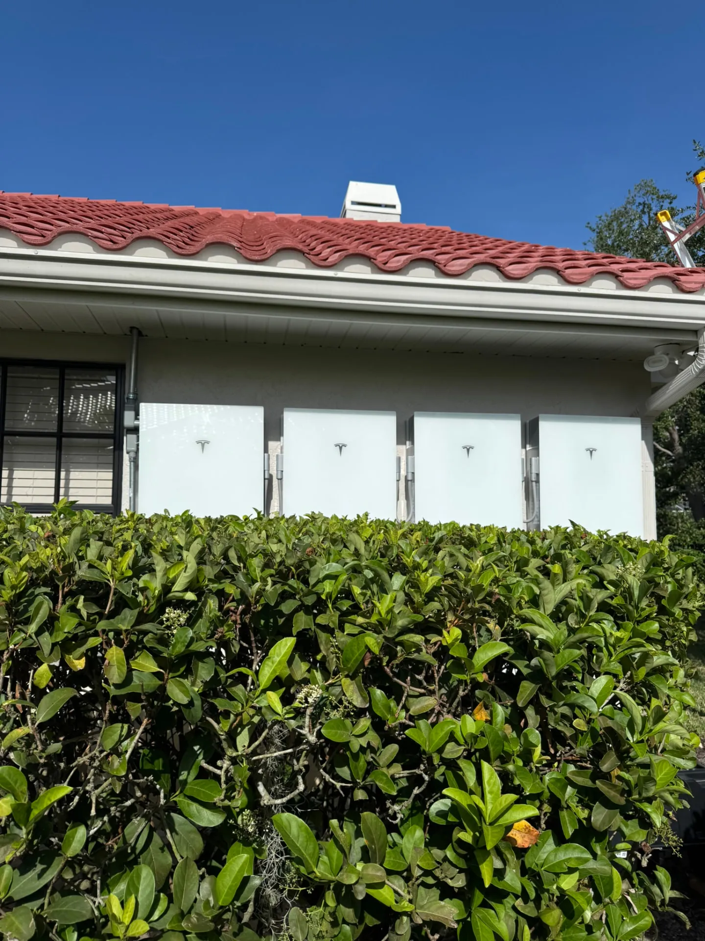 Four Tesla Powerwalls installed at a Naples home with a red tile roof