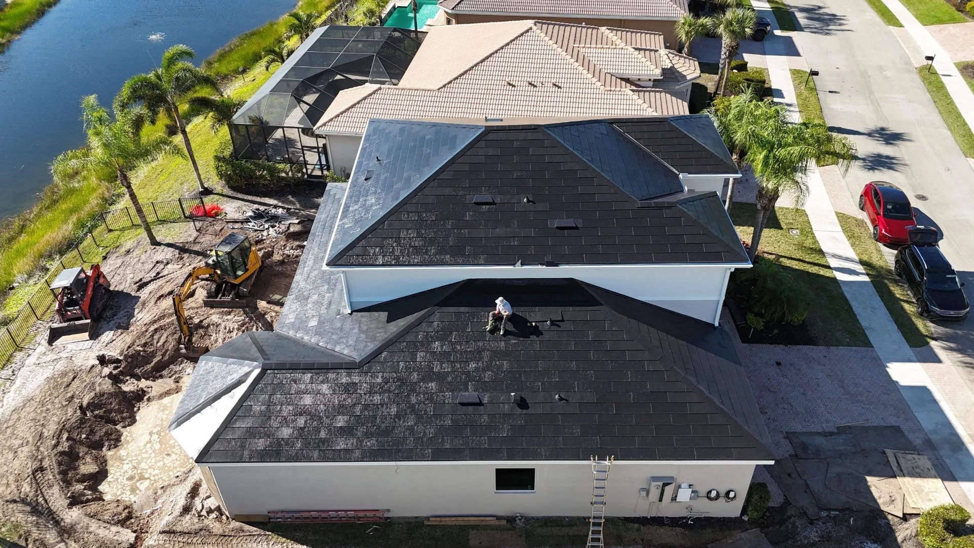 Angled aerial of a lakefront Florida home during a roof replacement