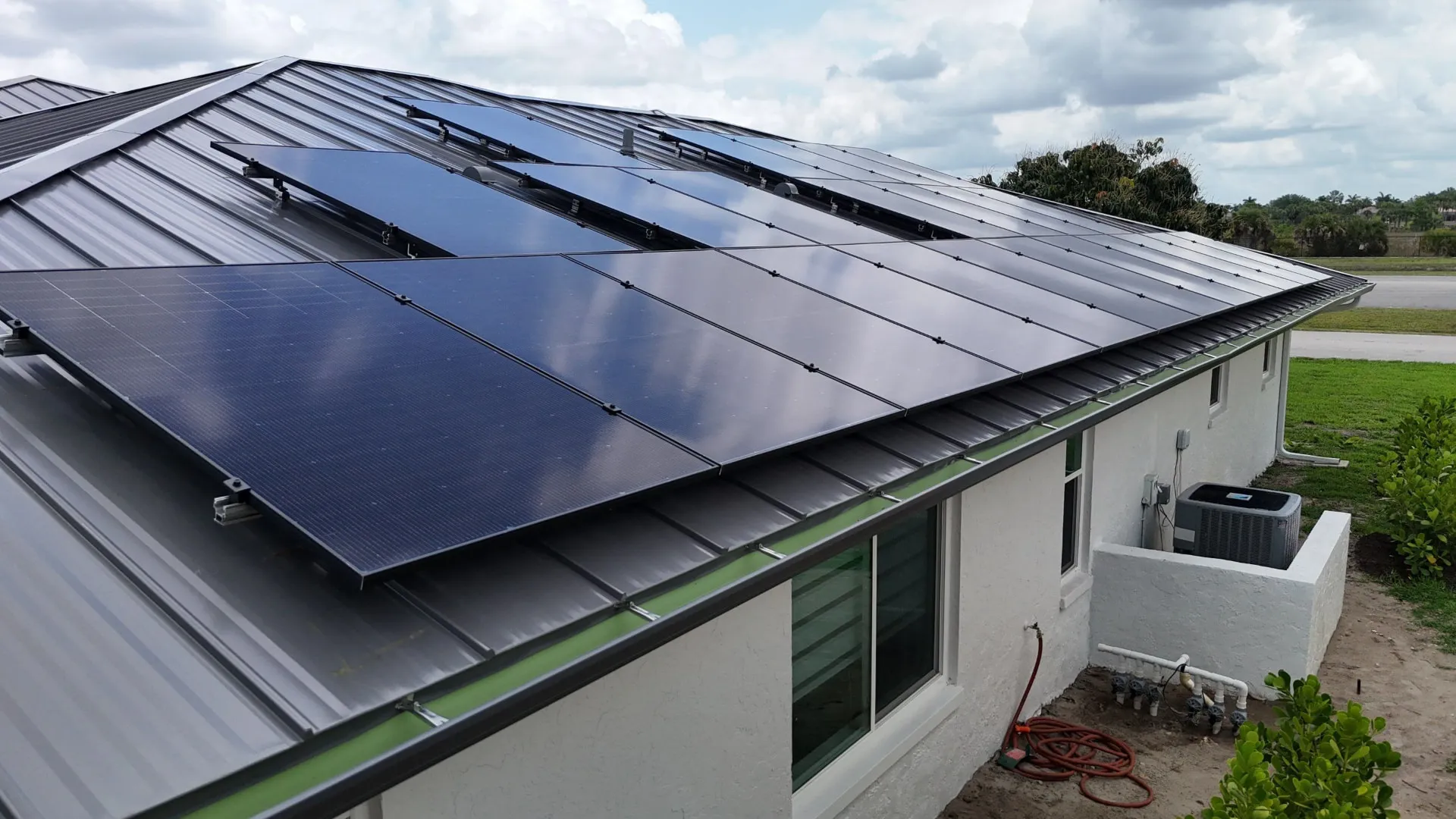 Conventional solar panel array on a dark standing seam metal roof in Florida