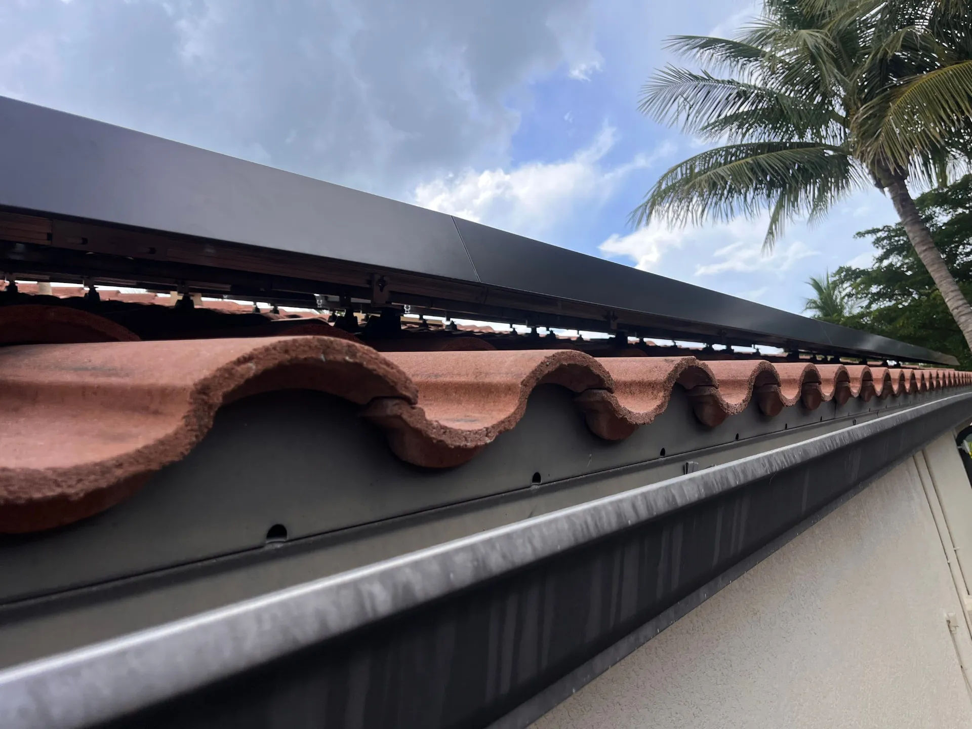 Solar mounting rail and flashing detail along a tile roof eave