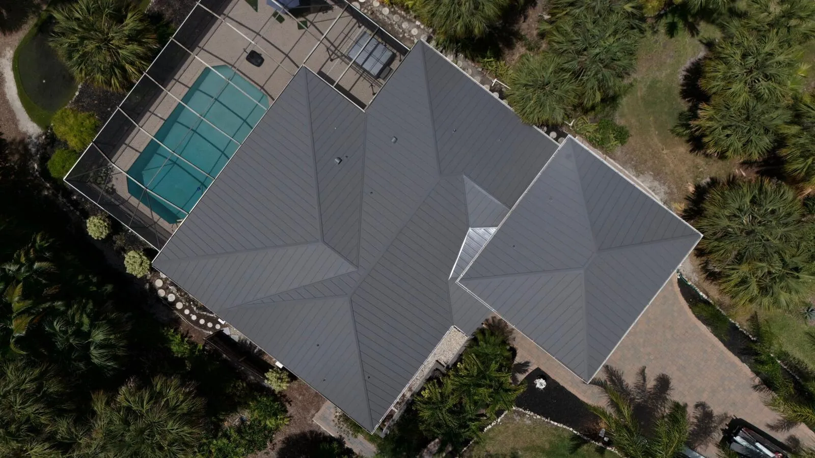 Top down view of a finished standing seam metal roof on a Florida pool home