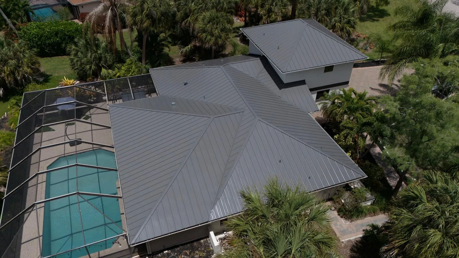 Wide aerial of a Florida estate with a completed charcoal standing seam metal roof