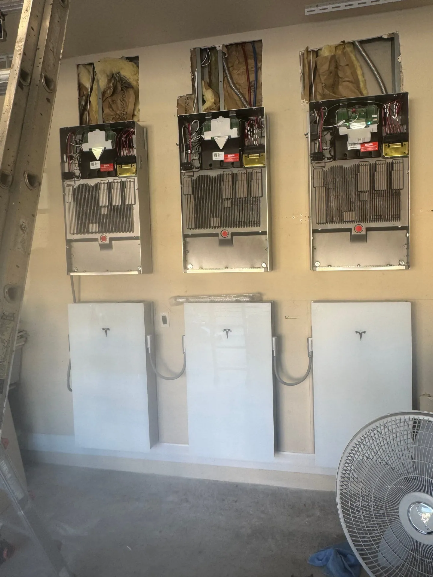 Three Tesla Powerwall batteries and gateways installed in a Florida garage