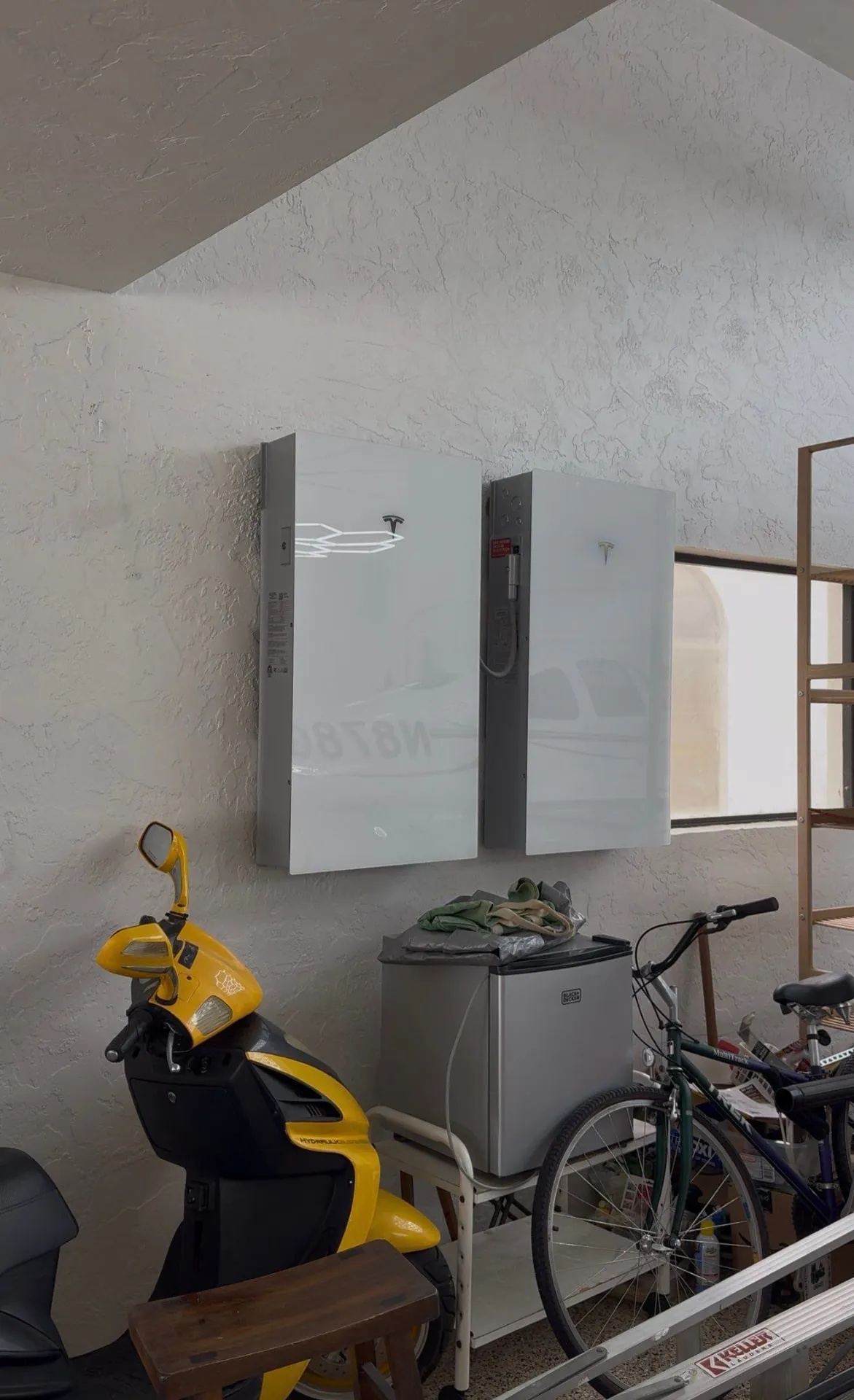 Two Tesla Powerwall batteries mounted on a Florida garage wall
